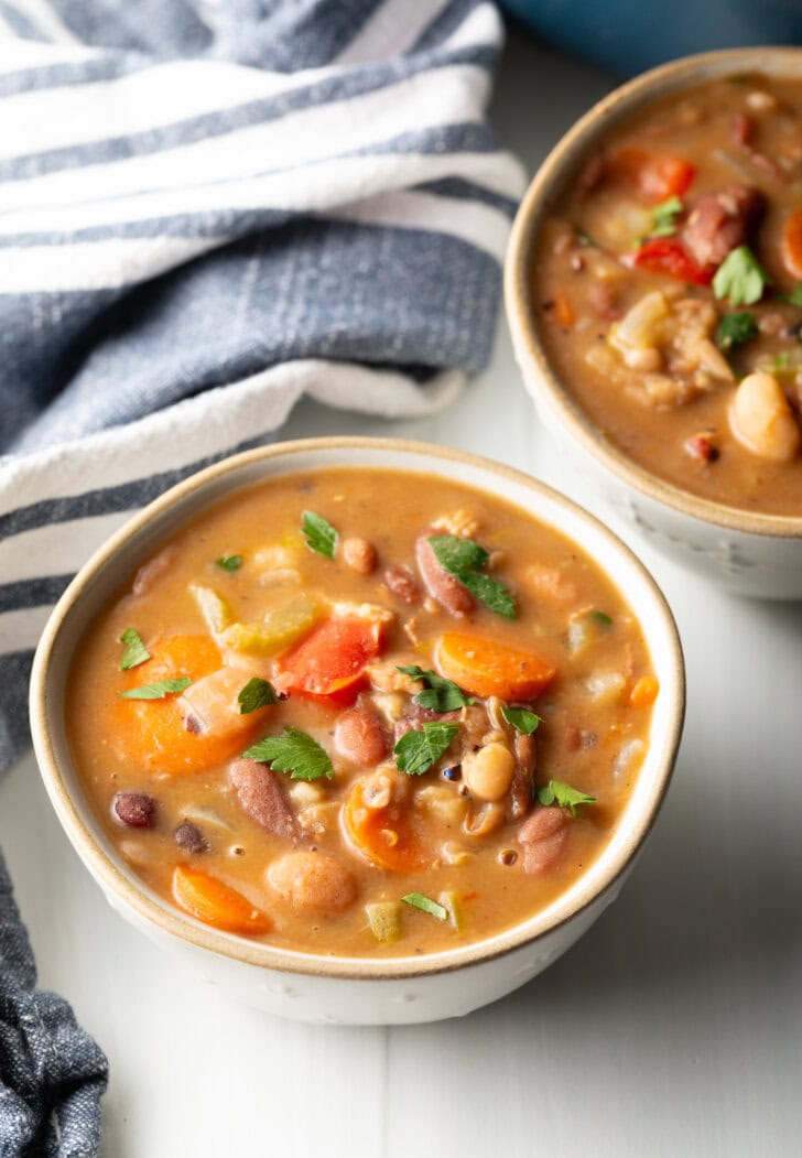 Two white bowls of 15 bean soup.