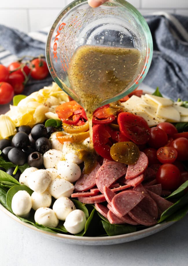 Pouring dressing over the salad.