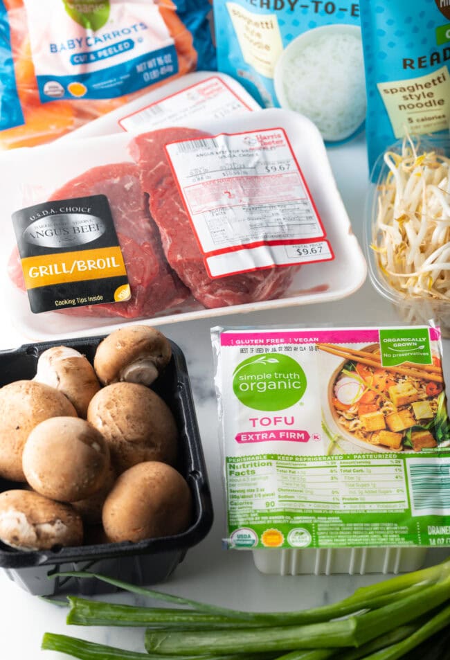 Recipe ingredients in packages: steak, mushrooms, tofu, carrots, and bean sprouts.