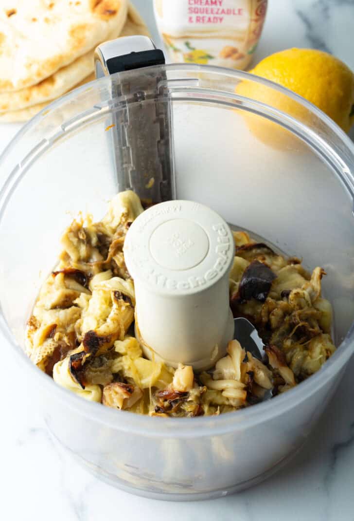 Chopped roasted garlic and eggplant in a food processor.