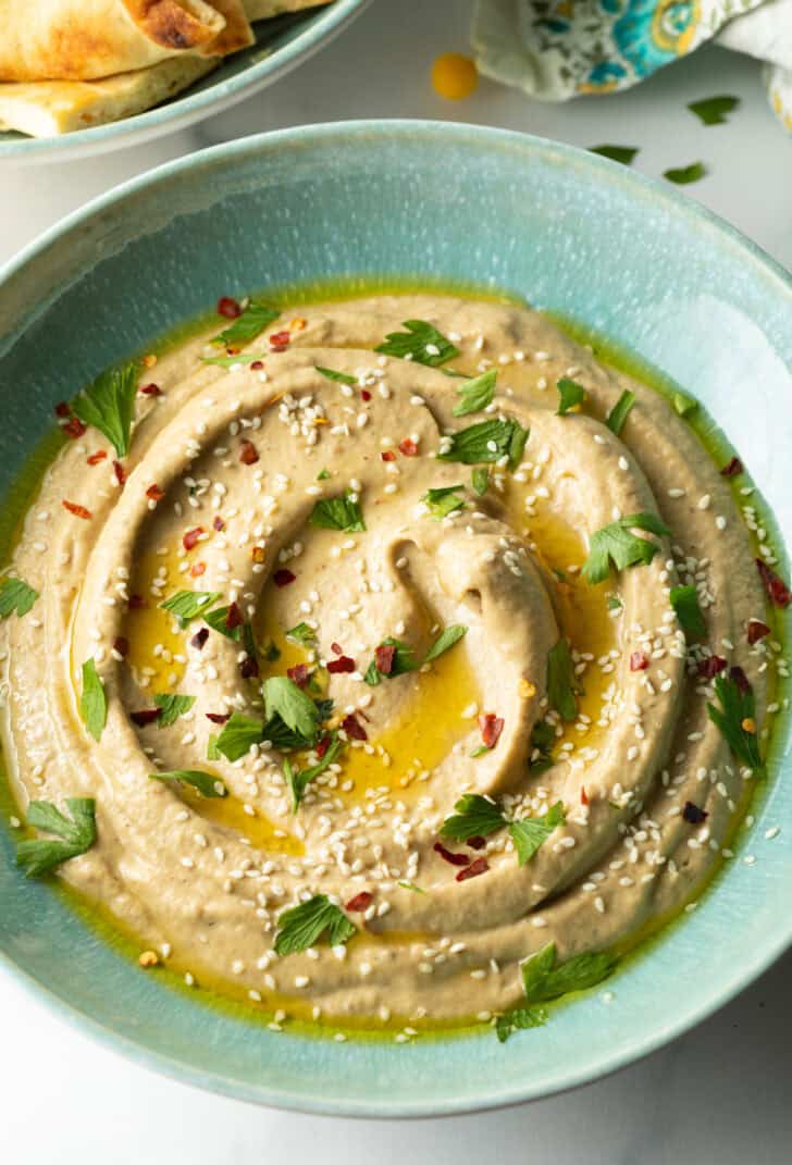 Top down view light blue bowl of baba ghanoush.