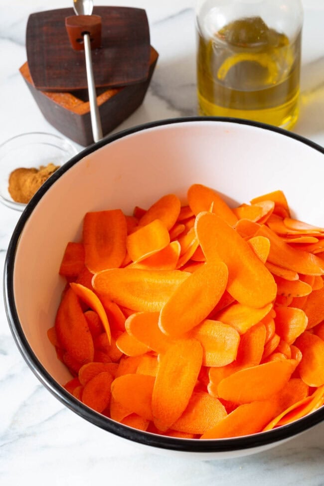 Sliced carrots in a mixing bowl. 