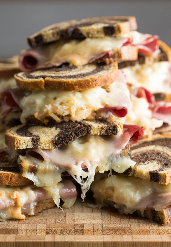 Reuben sandwiches piled on top of each other. 