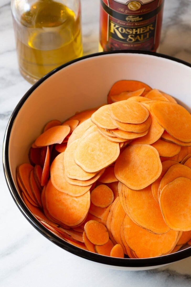 Sliced sweet potatoes in a mixing bowl. 