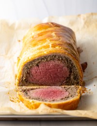 Sliced beef wellington on parchment paper.