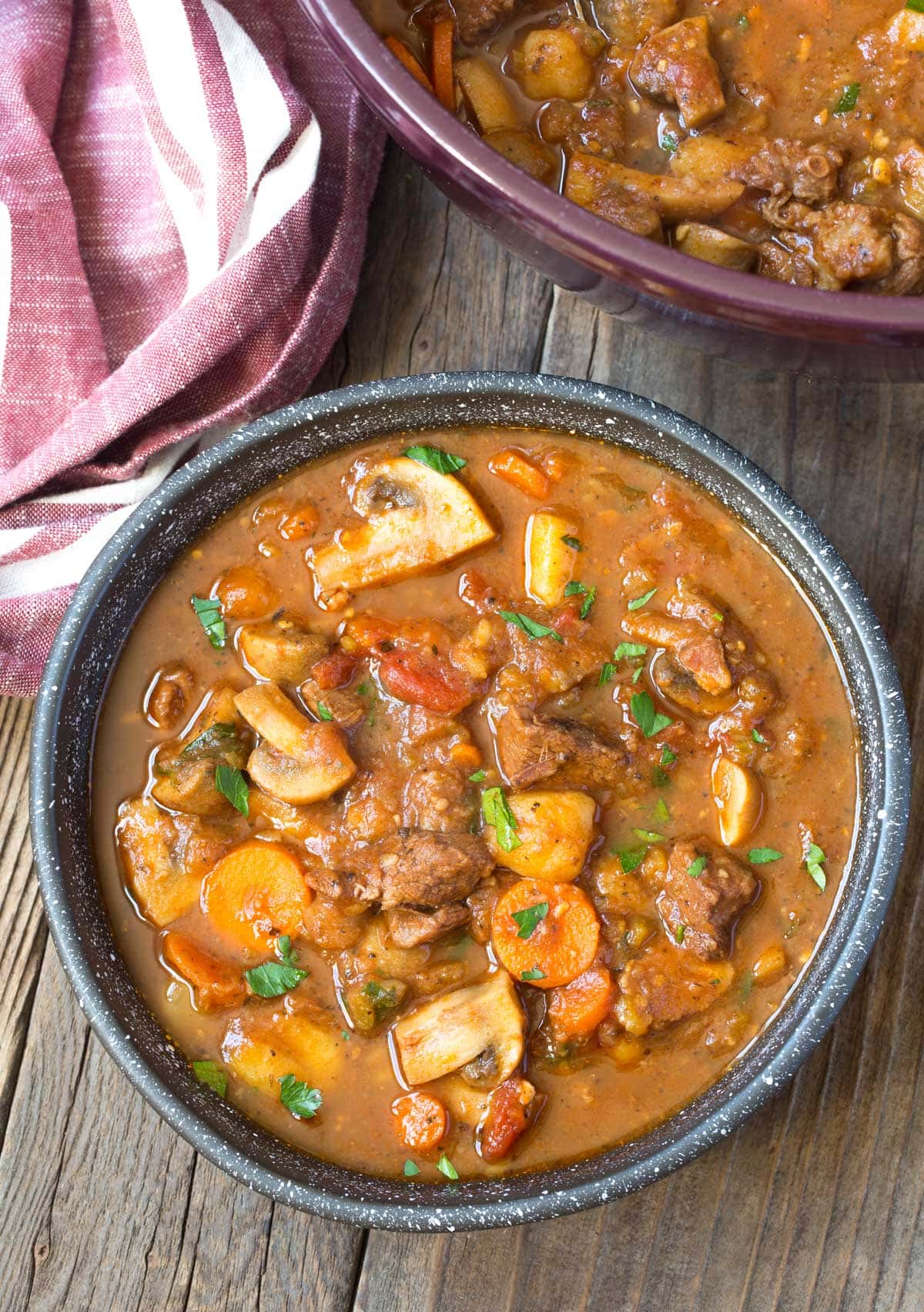 Bowl of easy beef stew with a pot of more beef stew in the background. 