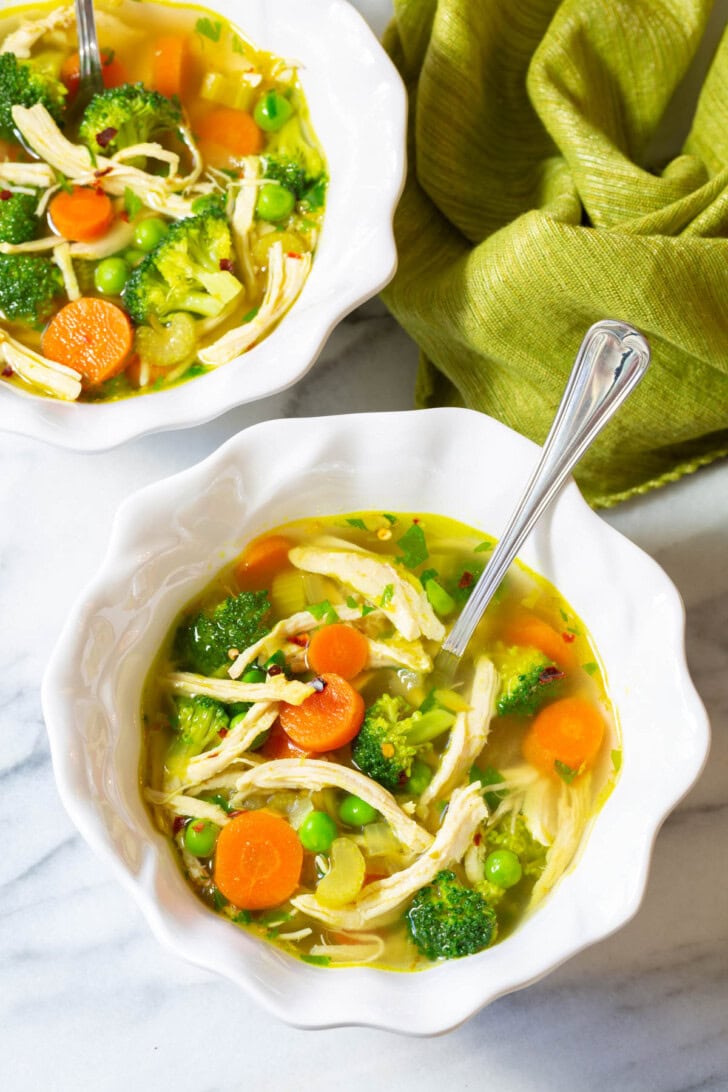 Two white bowls filled with chicken detox soup. 