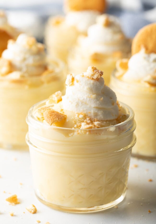 Vanilla Pudding Recipe - Small glass jar with pudding, topped with crushed vanilla wafers and whipped cream.