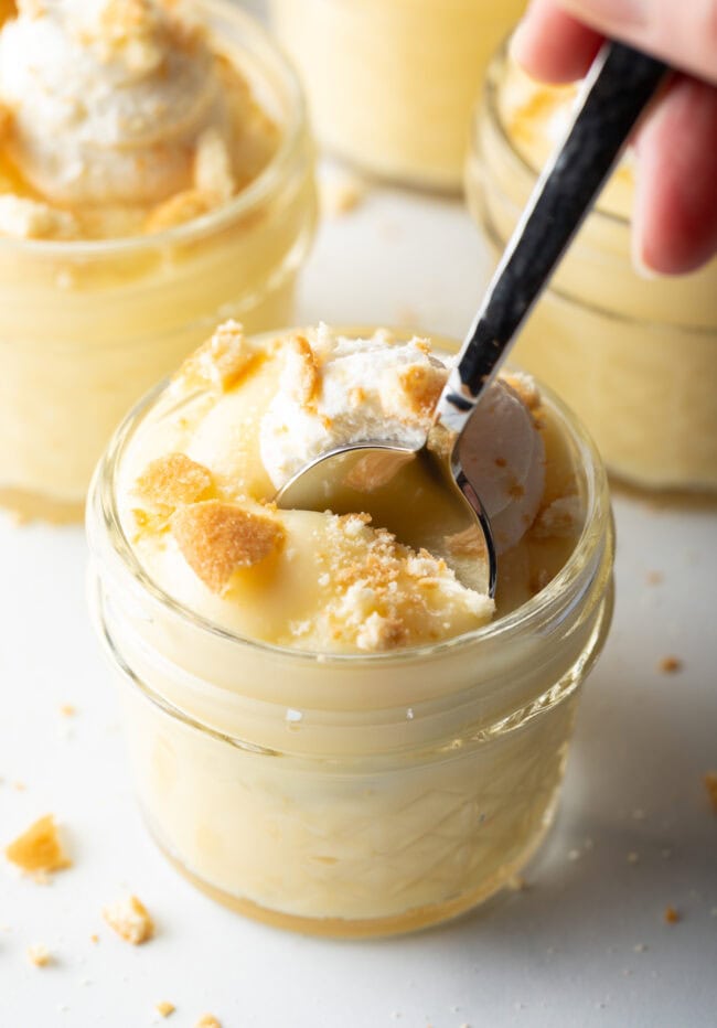 Spoon scooping pudding from a small jar.