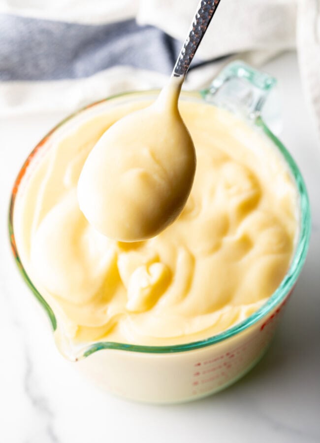 Spoon holding spoonful of homemade pudding to camera.