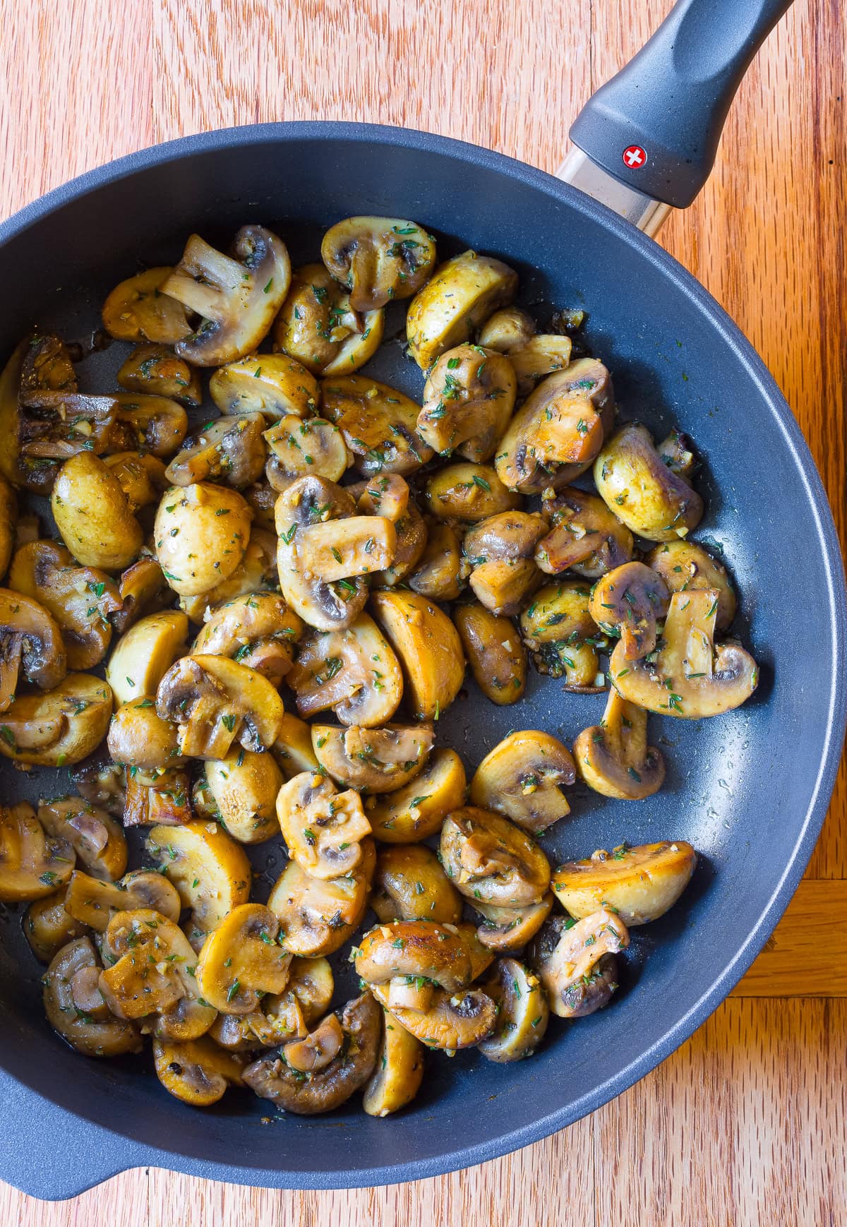 Top view of a skillet with sauteed mushroom recipe in it. 
