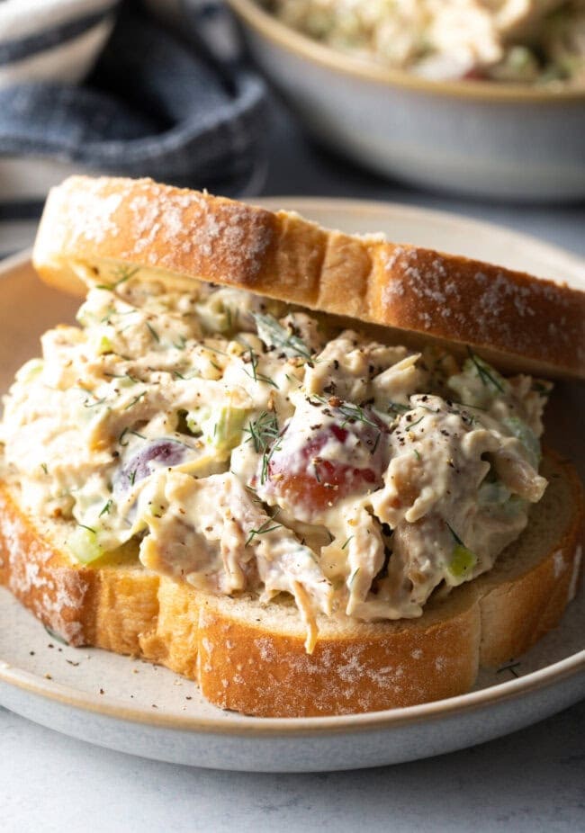 Large turkey salad sandwich on a white plate. Final shot of leftover turkey recipe post.