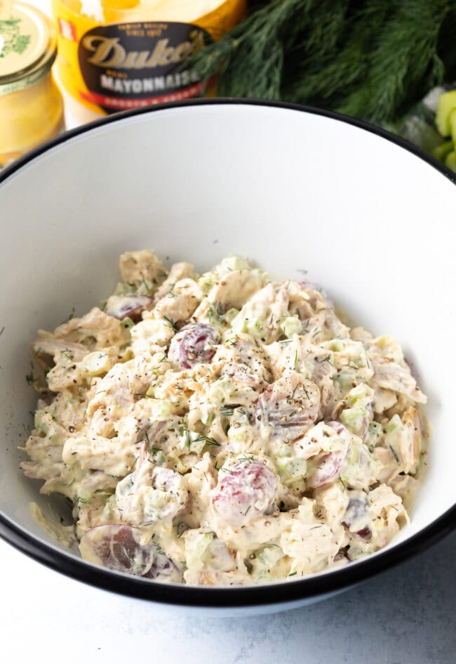 All ingredients for leftover turkey salad combined in white bowl.