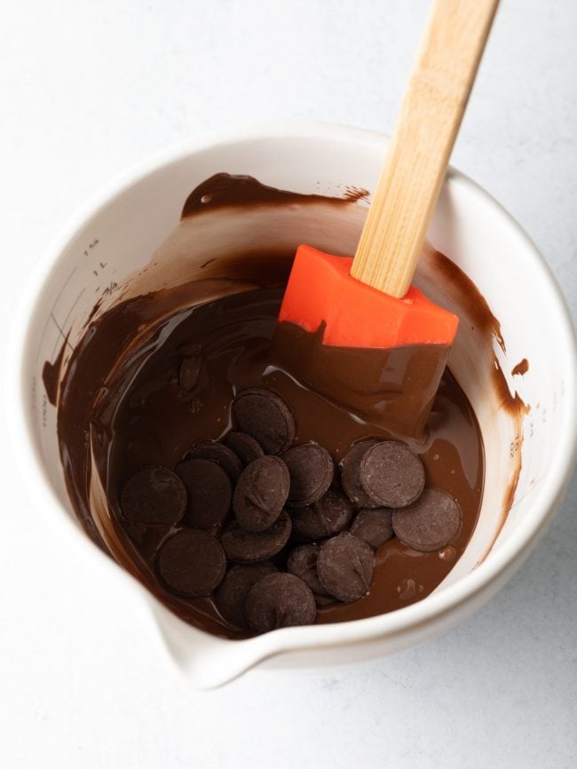 chocolate wafers meting in a white measuring cup with spatula