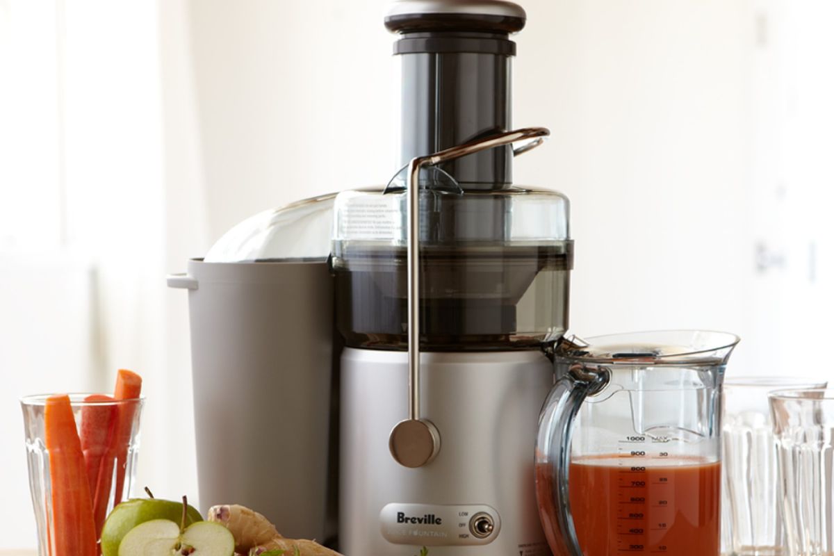 Photo of juicer with carrot juice. 