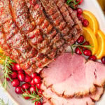 Brown Sugar Ham (Baked Ham Glaze Recipe) sliced ham on platter with garnishes