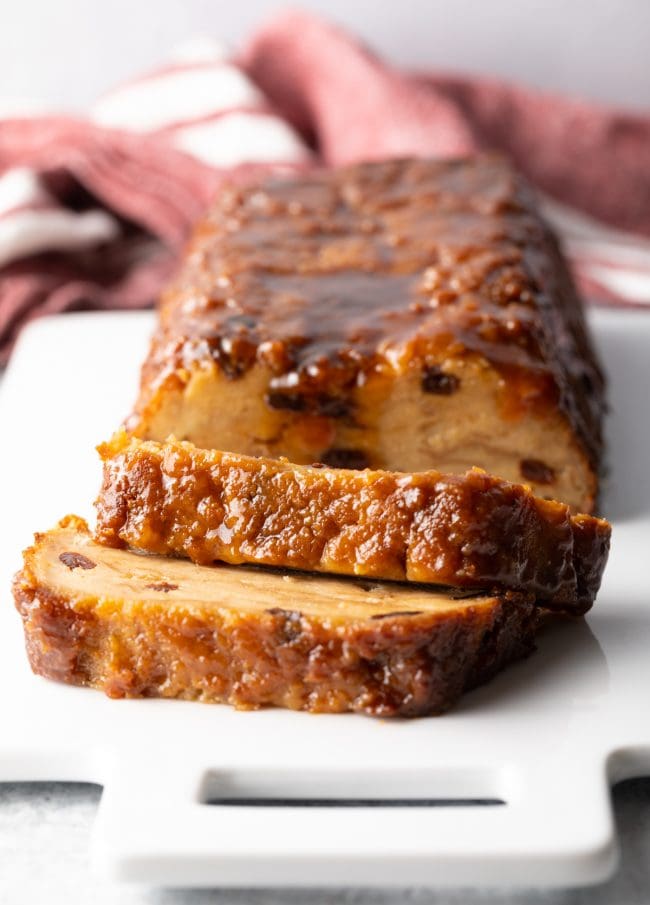 Front view of budin de pan sliced on a white board.