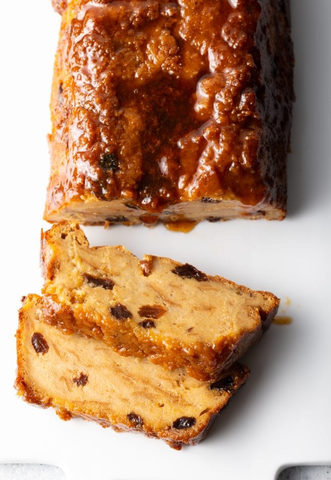 Top view Mexican bread pudding loaf on a white board with two slices.