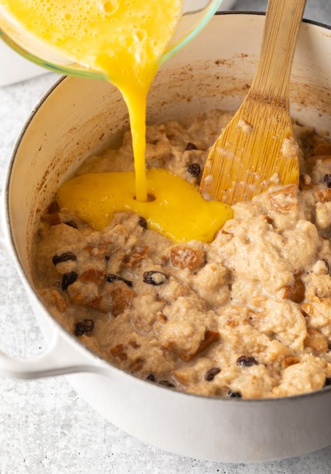 Adding eggs to the Mexican bread pudding mixture.