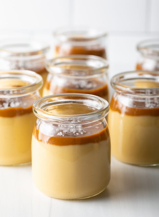 Budino Dessert Recipe - side view several glass jars filled with caramel and butterscotch pudding