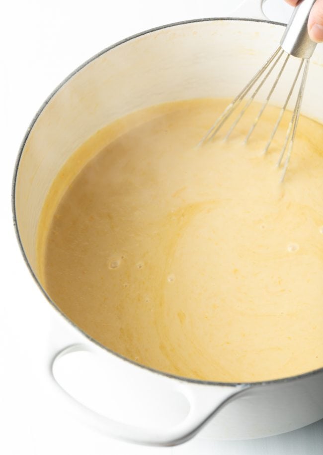 whisking egg yolks and half and half into the mixture