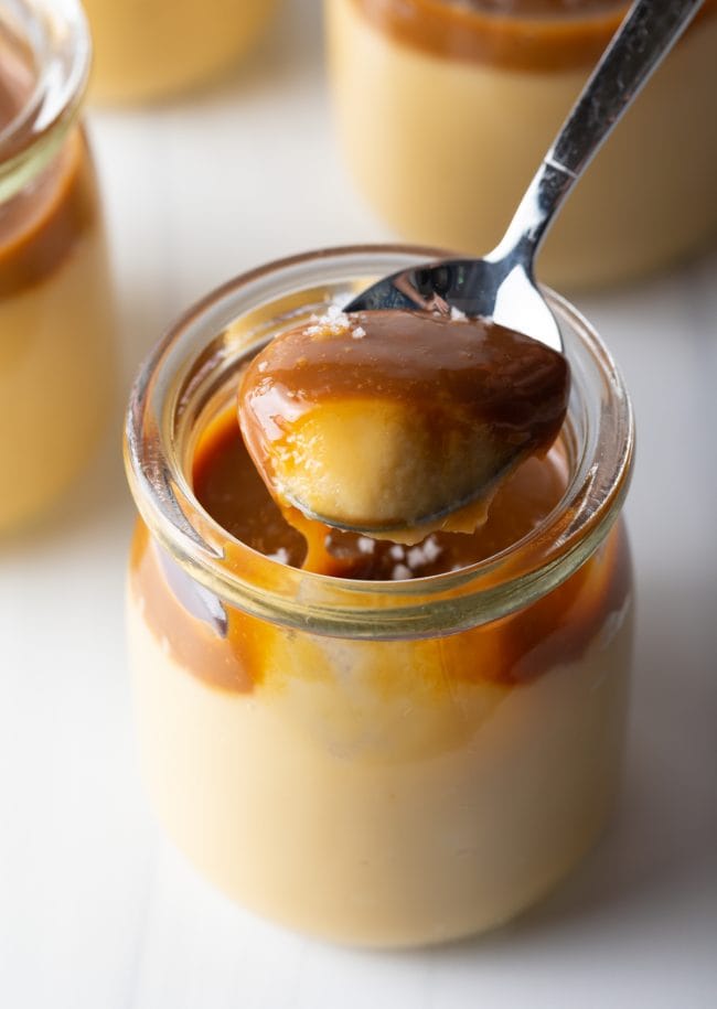 spoon scooping budino with butterscotch and salted caramel topping