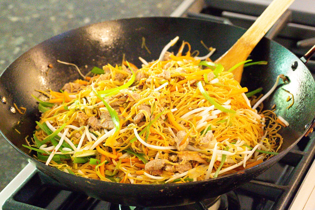 Making lo mein in a large wok - pan fried noodles