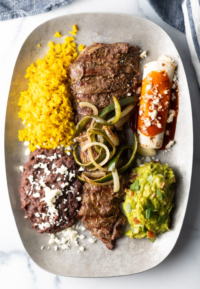 Plate of tampiquena steak with guacamole, rice, and beans