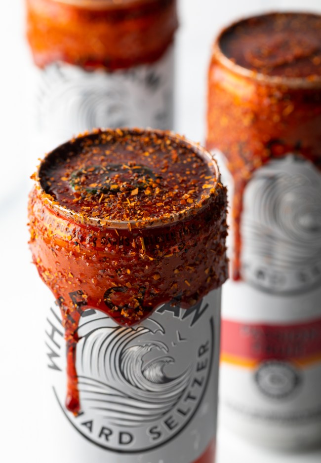 Close view aluminum beverage can with spicy dip and extra tajin seasoning.