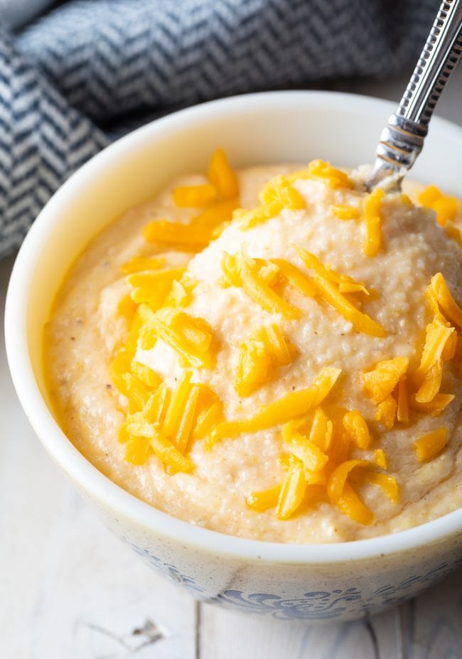 Close up of cheese grits recipe in a bowl with a spoon. 