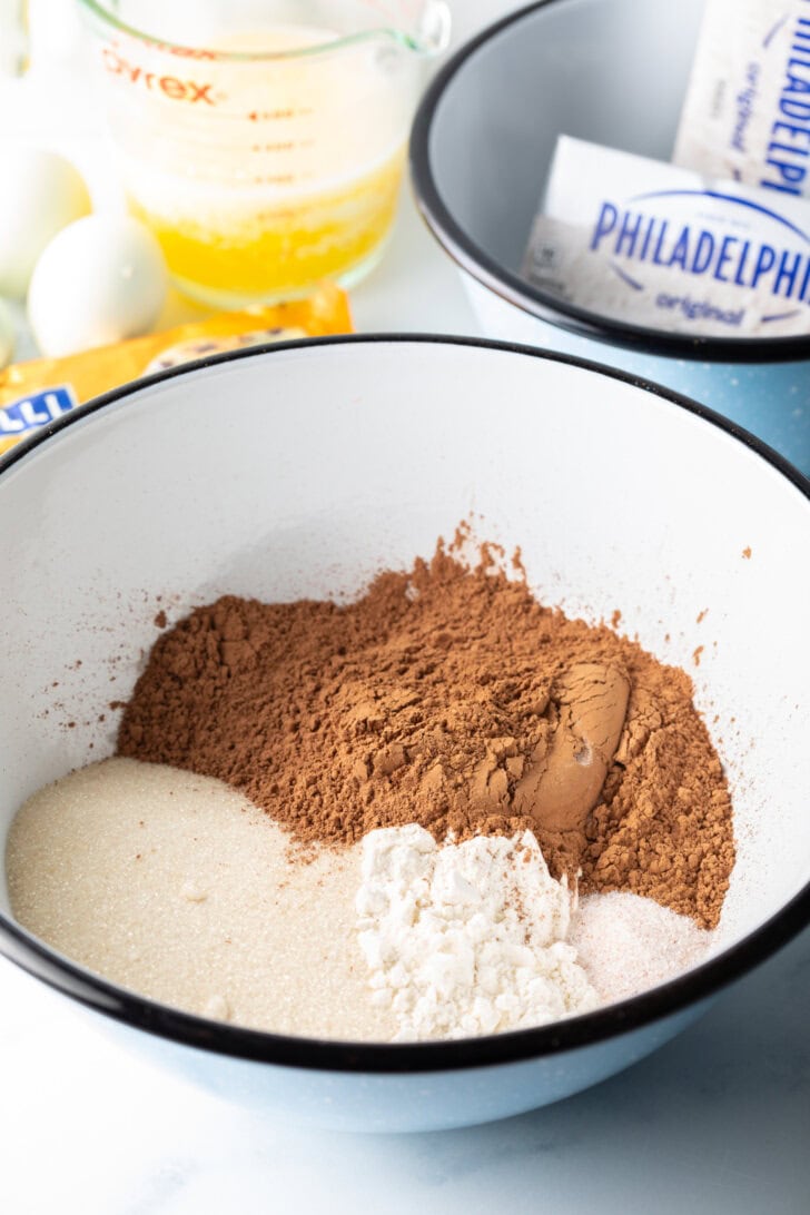 White bowl with cocoa powder and other dry ingredients.