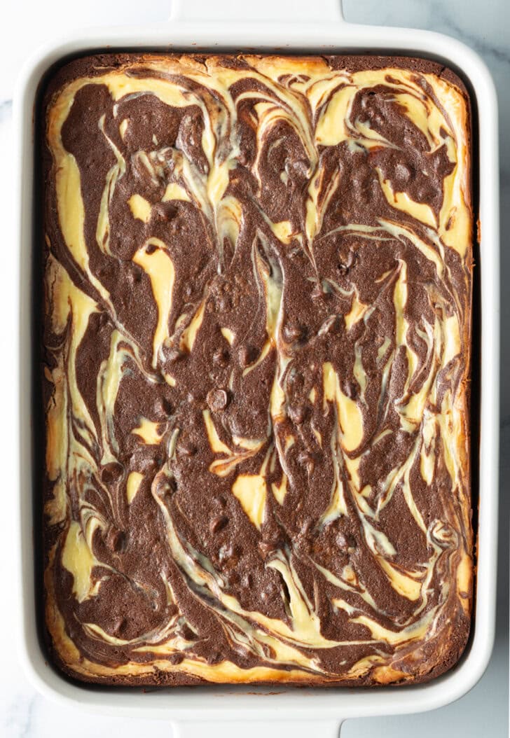 Baked brownies in a pan with cream cheese and chocolate swirl.