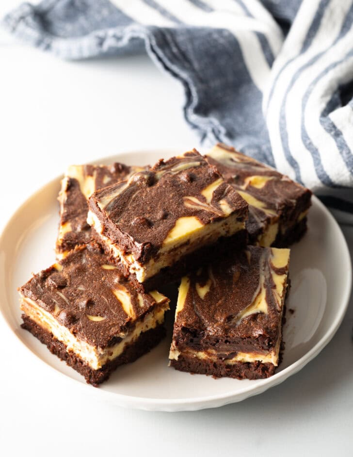 Top down view of plate of 5 brownies, one brownie stacked on top.