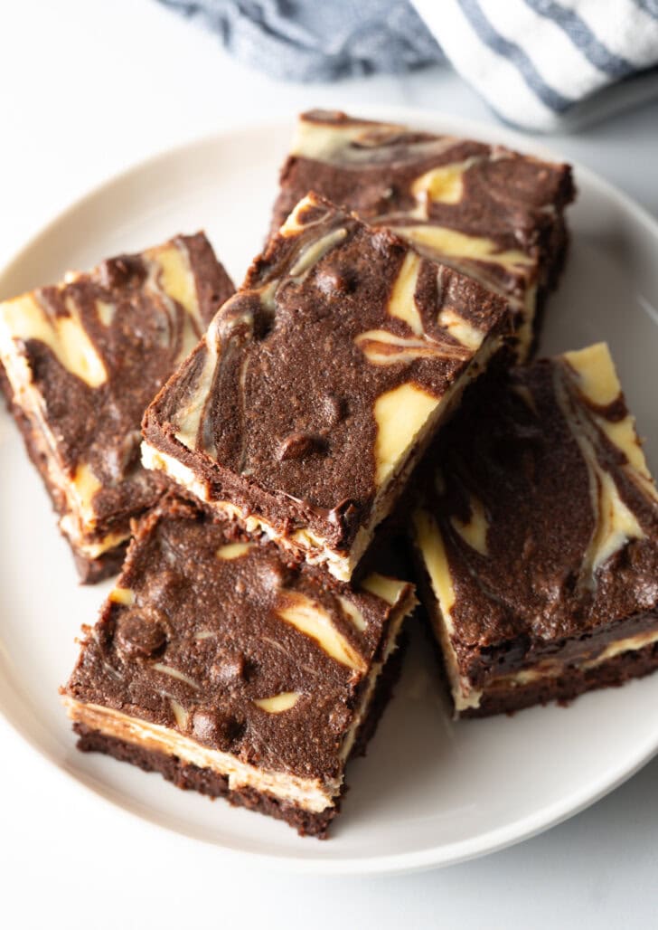 Top down view of plate of 5 brownies, one brownie stacked on top.