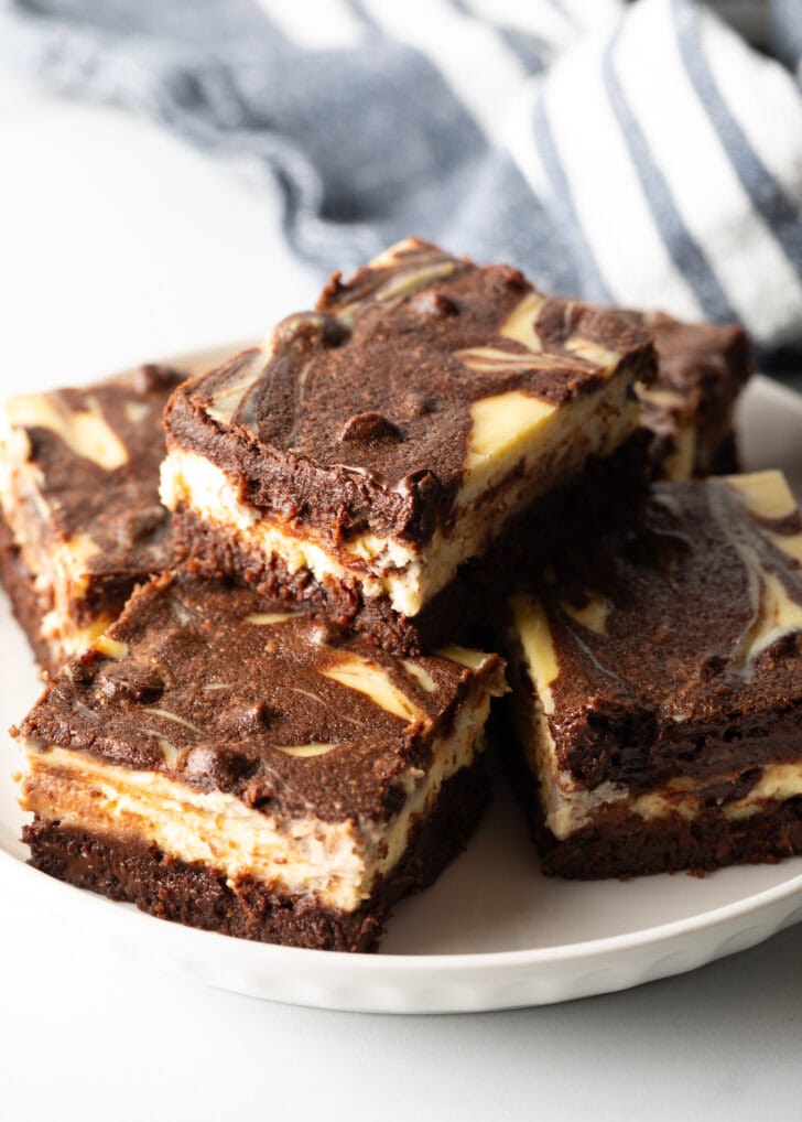 Plate of 5 brownies, one brownie stacked on top.