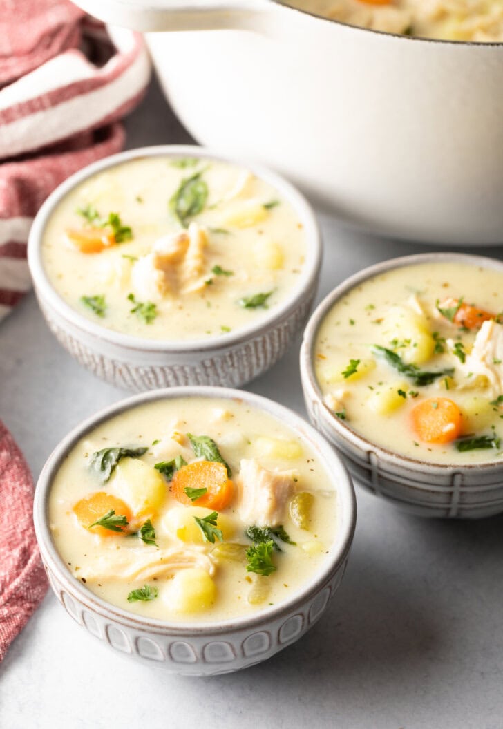 3 white bowls of olive garden chicken gnocchi soup.