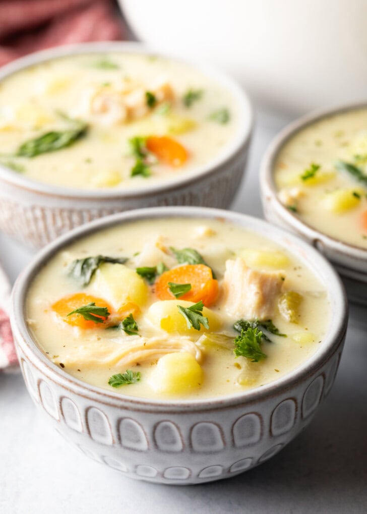 3 white bowls of chicken gnocchi soup.