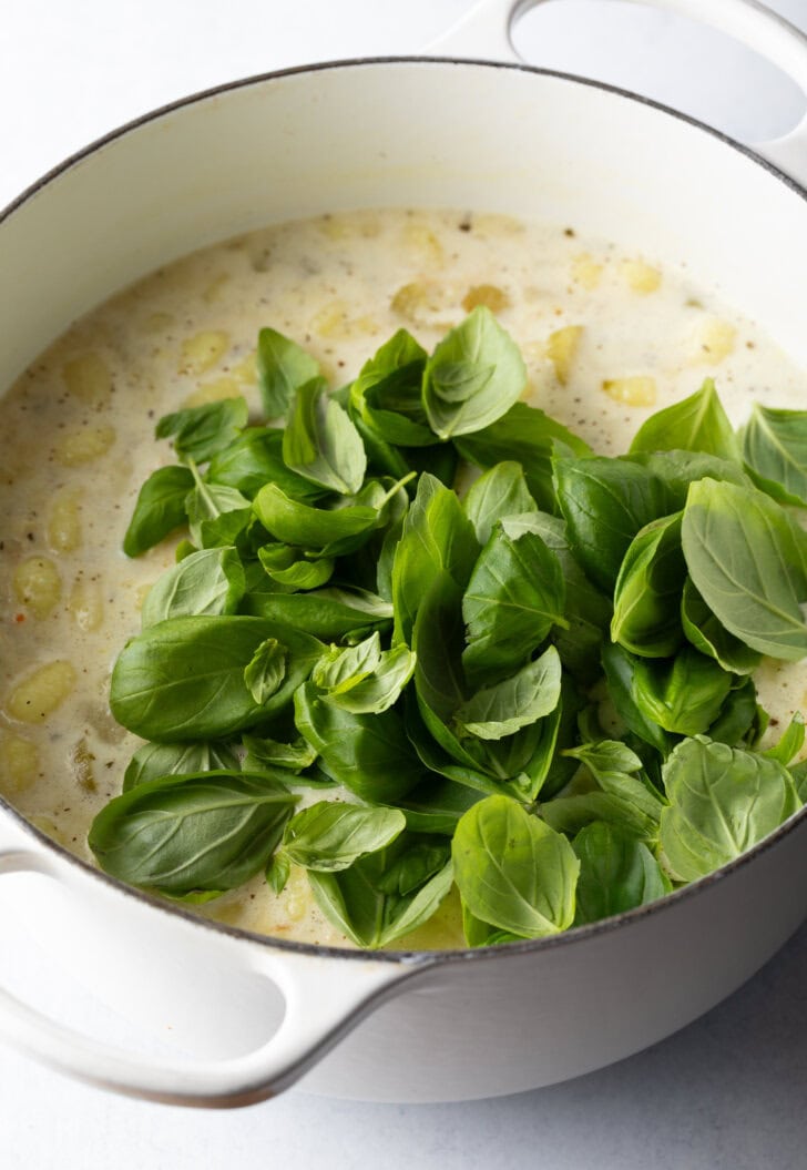 Adding fresh spinach to the cooking pot.