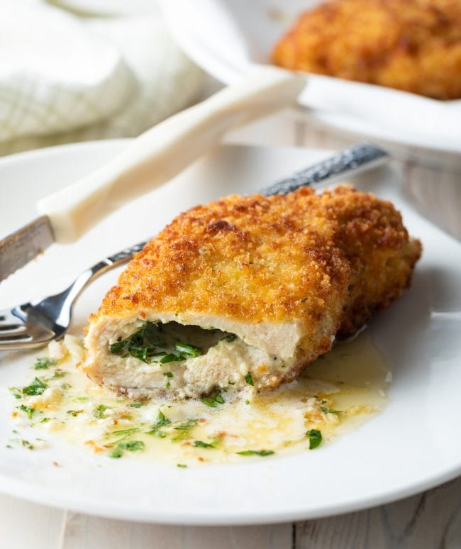 Chicken kiev cut in half and served on a plate. 