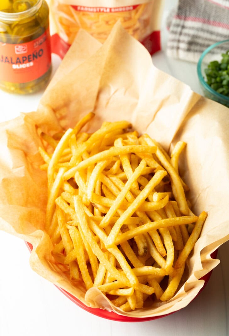 Basket with parchment paper, filled with crispy fries.