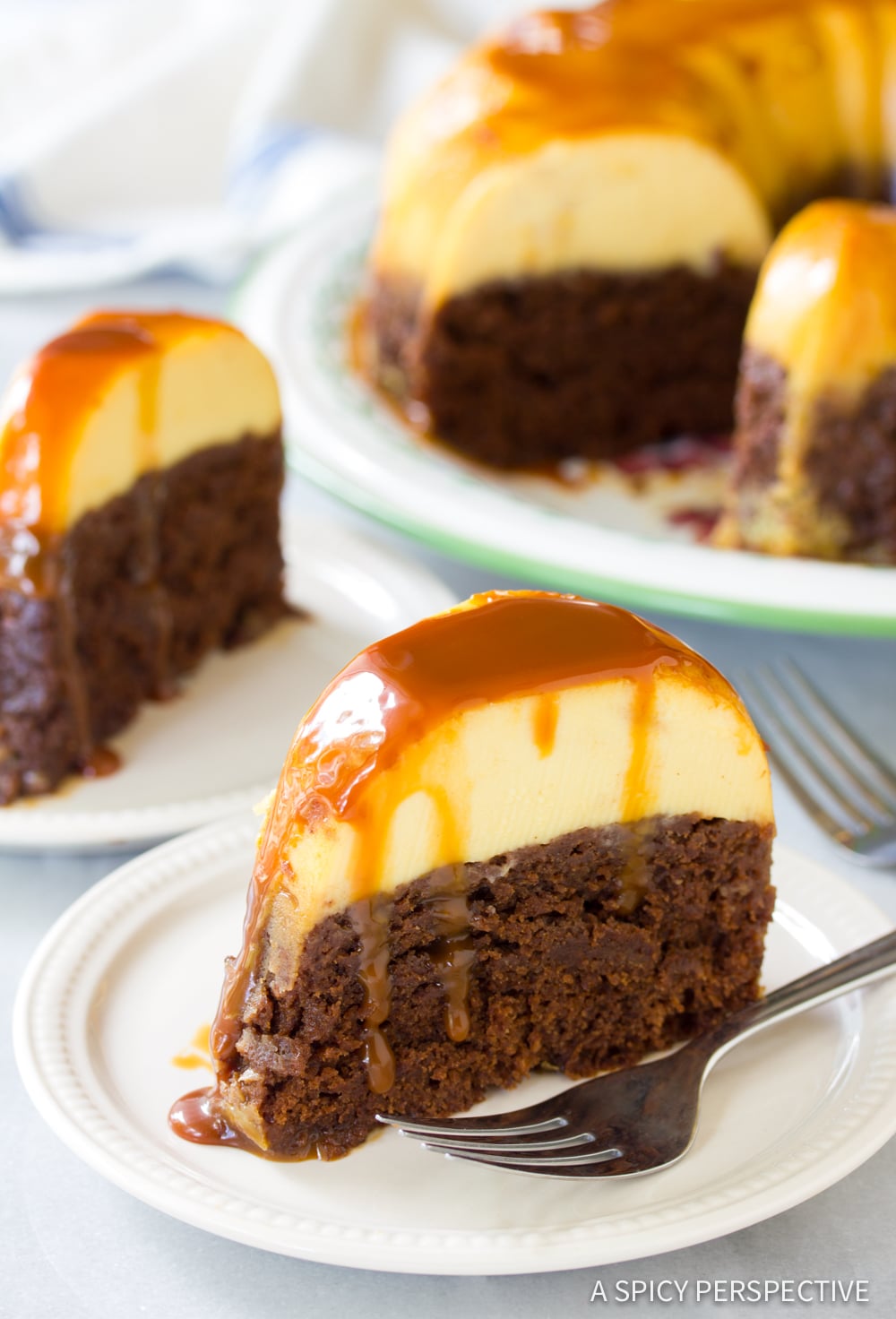 Slices of impossible cake on plates with the rest of the cake in the background. 