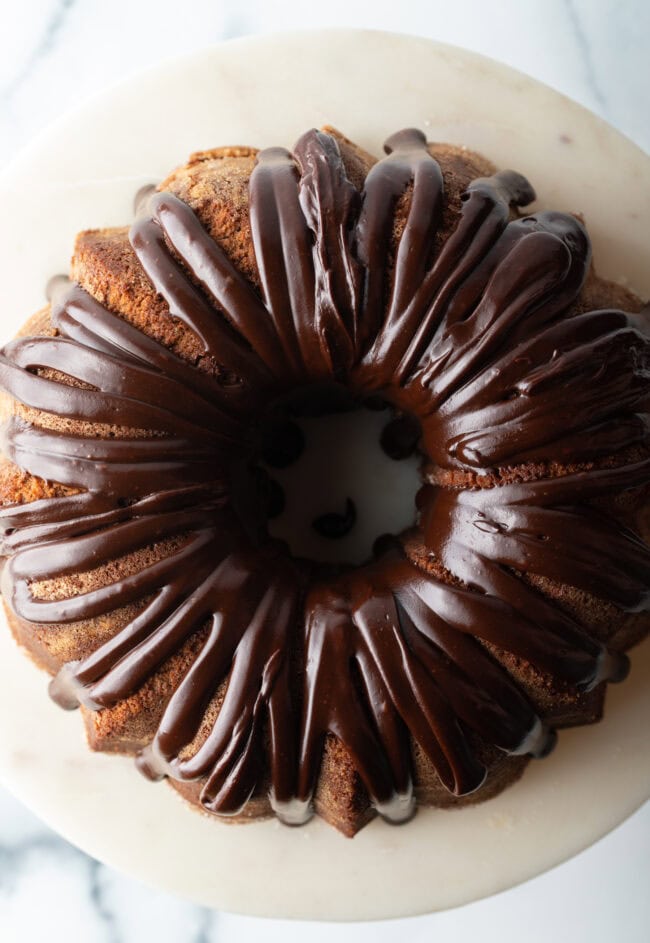 Top down view, circular chocolate sour cream bundt cake with a thick chocolate glaze drizzled on top.