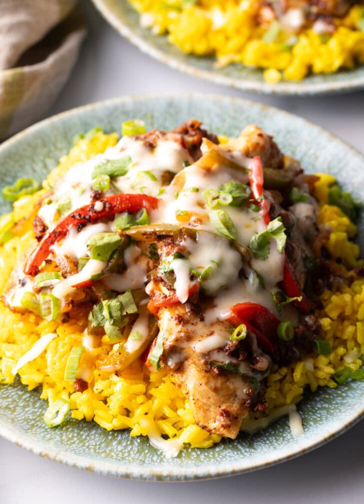 Chori pollo (chicken chorizo) covered in cheese on a bed of yellow rice.