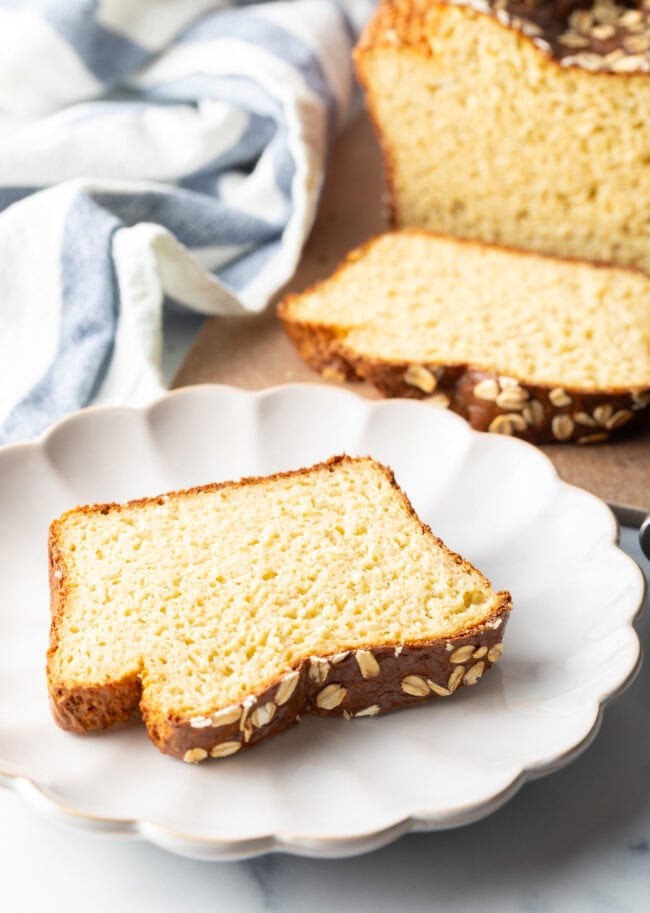 Slice of gluten free oatmeal bread on a white plate.