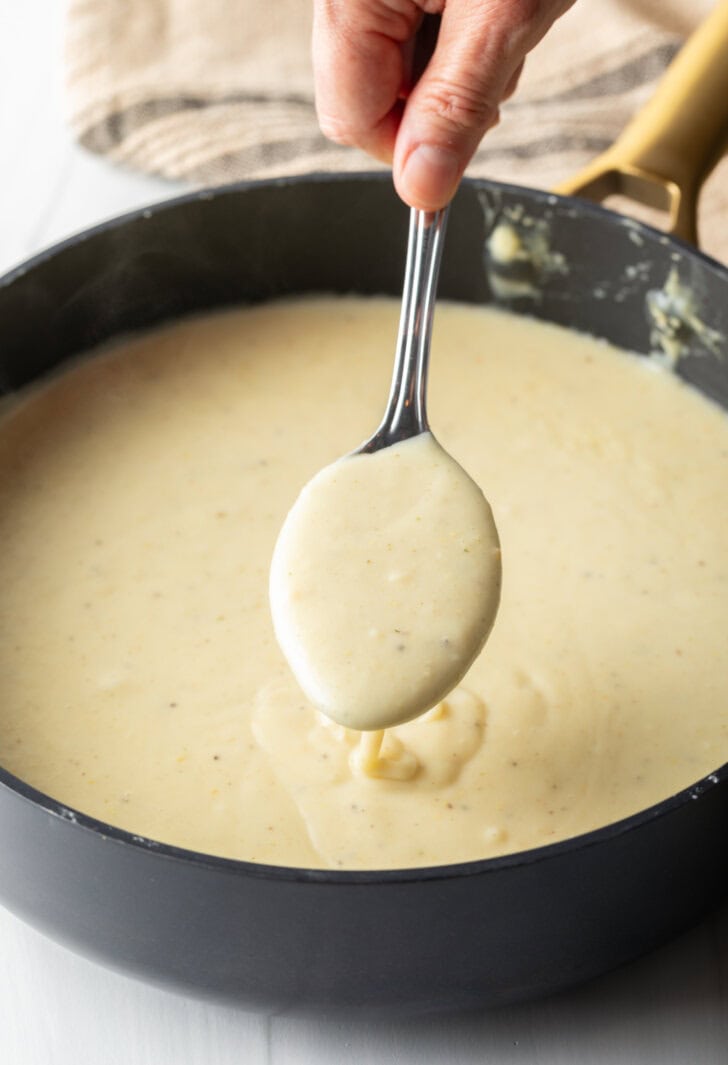 Large cooking post with soup being stirred by a large metal spoon.