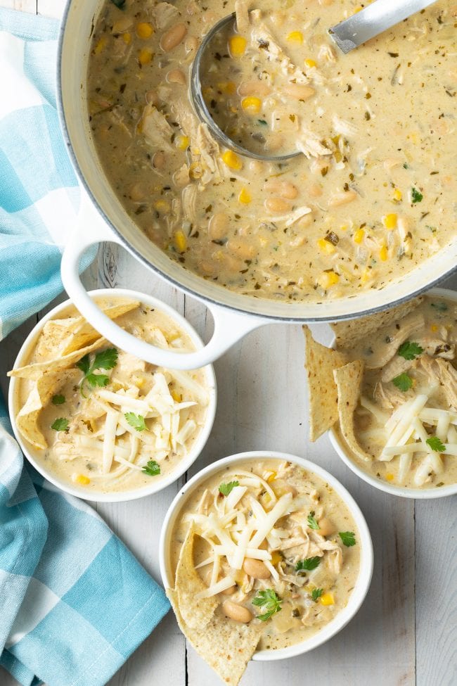 slow cooker, crock pot, instant pot white chicken chili recipev- overhead shot in pot with bowls on the counter