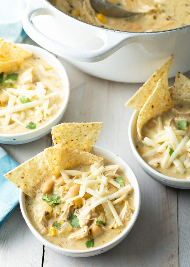 how to make creamy white chicken chili - bowls of chili on table with chips