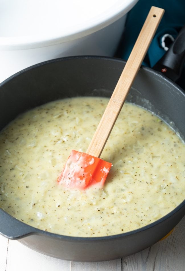 Gravy cooking in a skillet with a rubber spatula. 