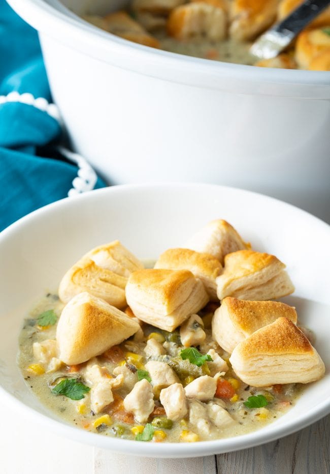 Chicken pot pie soup with small pieces of biscuit served on top in a bowl. 