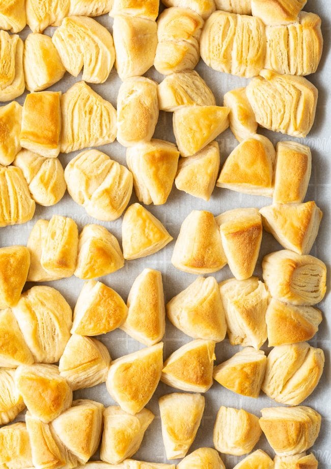 Biscuit triangles baked on a baking sheet lined with parchment paper. 